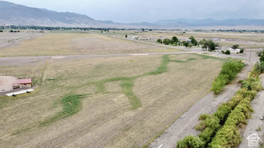 Expansive land, perimeter vegetation, and distant mountain backdrops