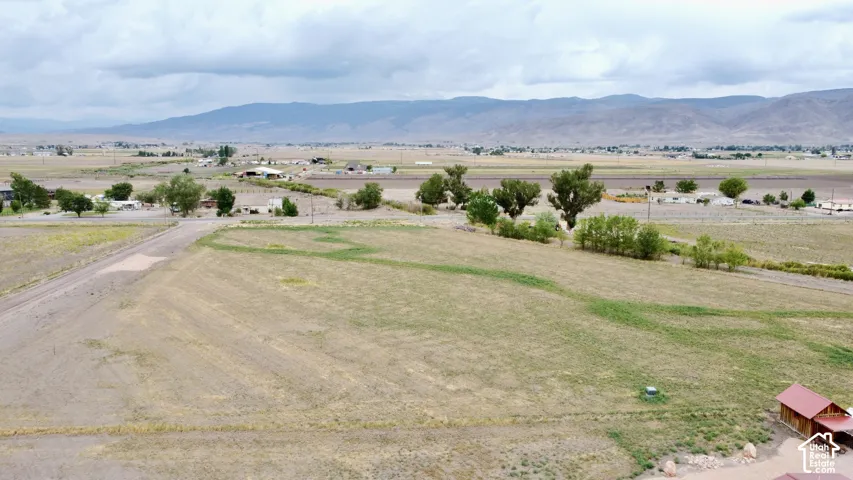 Expansive open land with varied terrain, surrounded by distant mountains