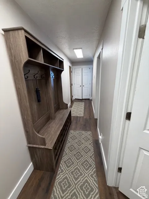 Built-in wood-finish hall tree with storage, wall hooks, and bench seating