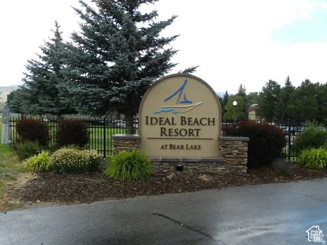 Resort entry sign featuring a curved stucco finish and stone base