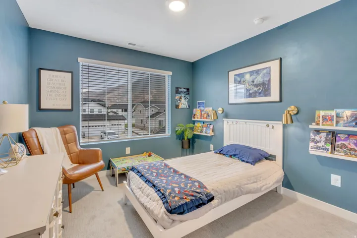 Window with integrated blinds, wall-mounted shelving, built-in ceiling light, wall-mounted sconces, and neutral carpet flooring