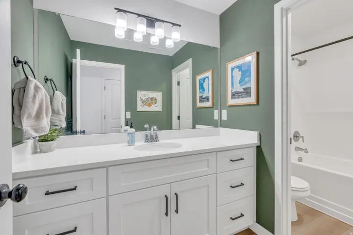 White vanity with black hardware, integrated sink, and white countertop