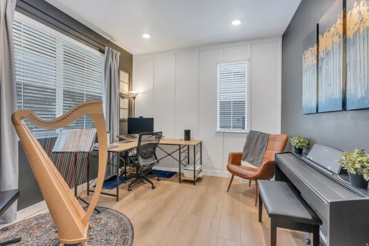 Light wood-finish flooring, recessed ceiling lighting, horizontal window blinds, and white vertical wall paneling