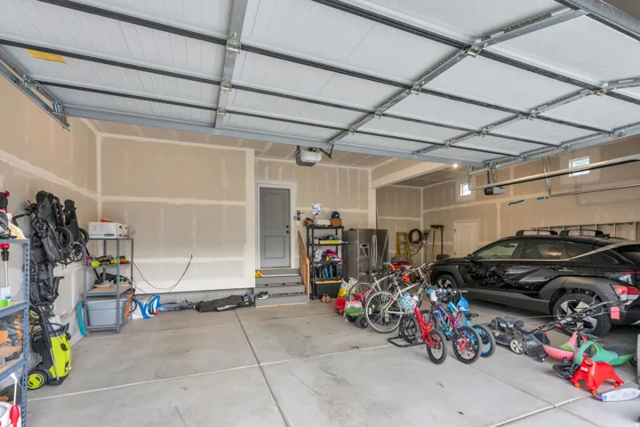 Spacious garage featuring a concrete floor, overhead garage door system, and interior access door
