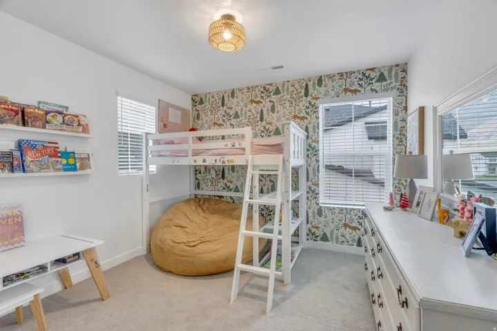 Plush carpet flooring, a decorative accent wall, and a woven pendant light fixture