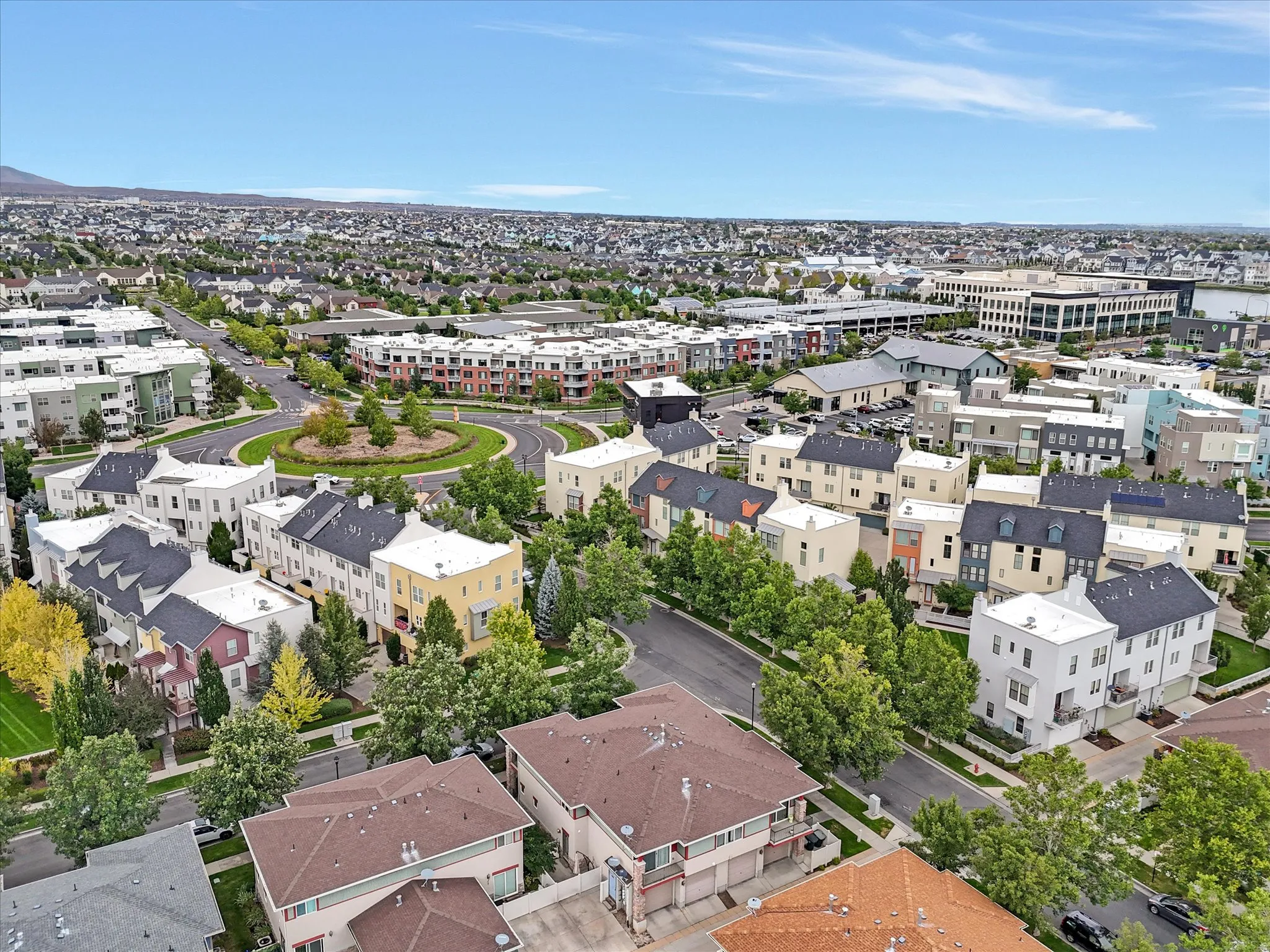 Aerial view of the property and community featuring custom-built homes with varied architectural styles, mature landscaping throughout the neighborhood, and mountain backdrop