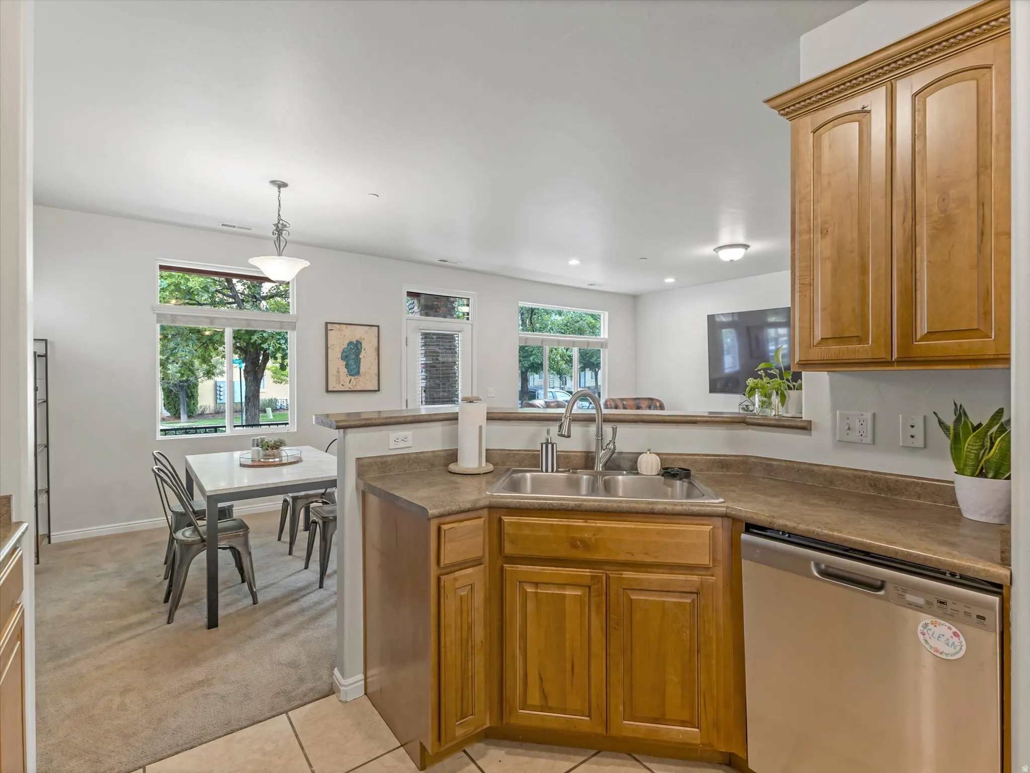 Kitchen with wood-finish cabinetry, stainless steel sink, and stainless steel dishwasher