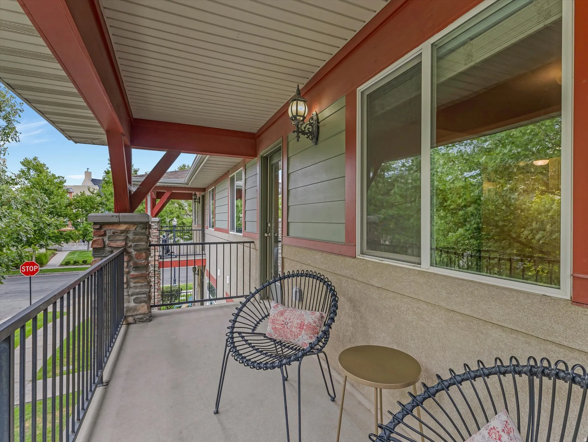 Expansive covered porch with steel railing, composite decking overlooking mature landscaping