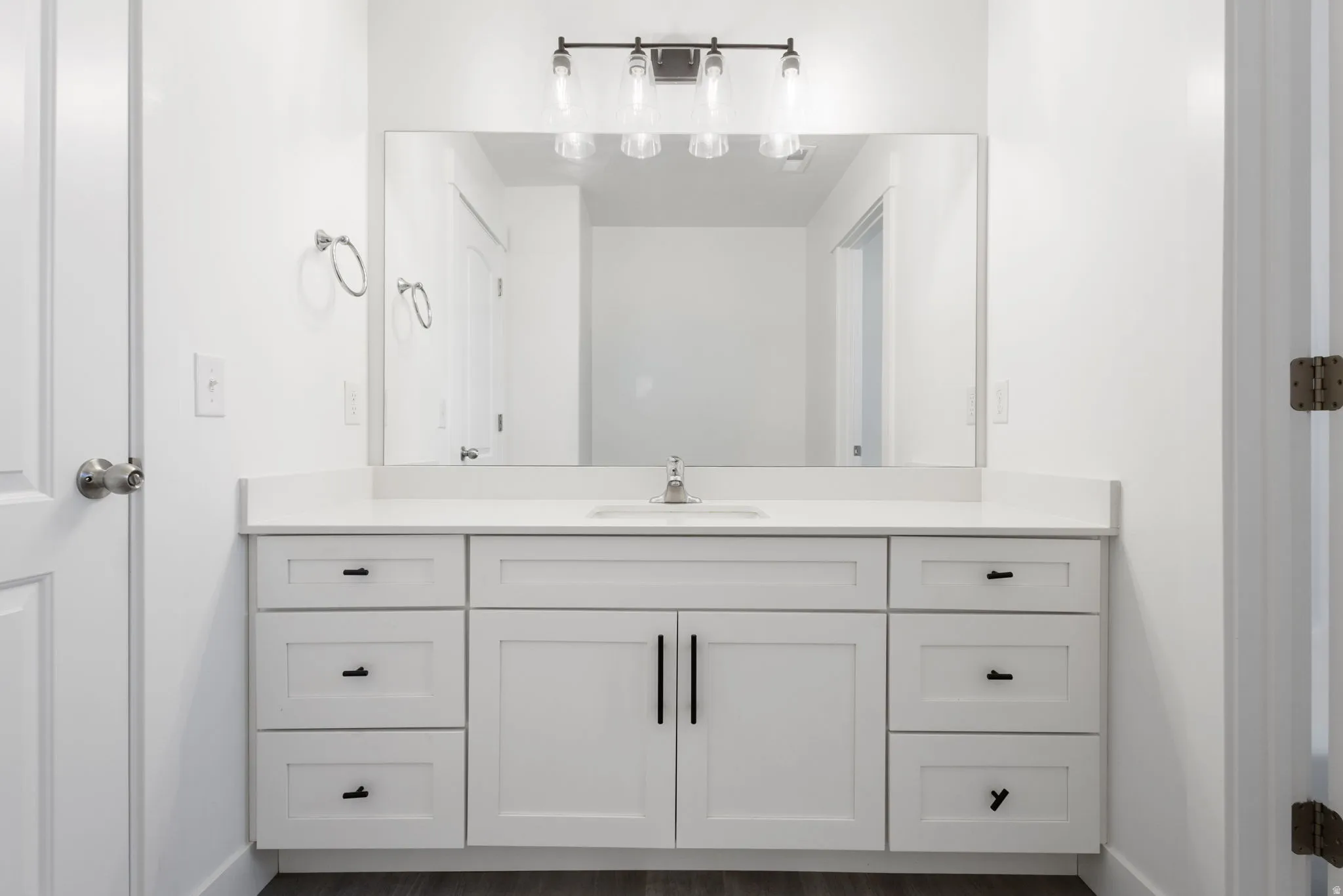 Spa-inspired primary bathroom vanity featuring a double-sink white cabinetry with ample storage, brushed nickel hardware, and a wide quartz countertop