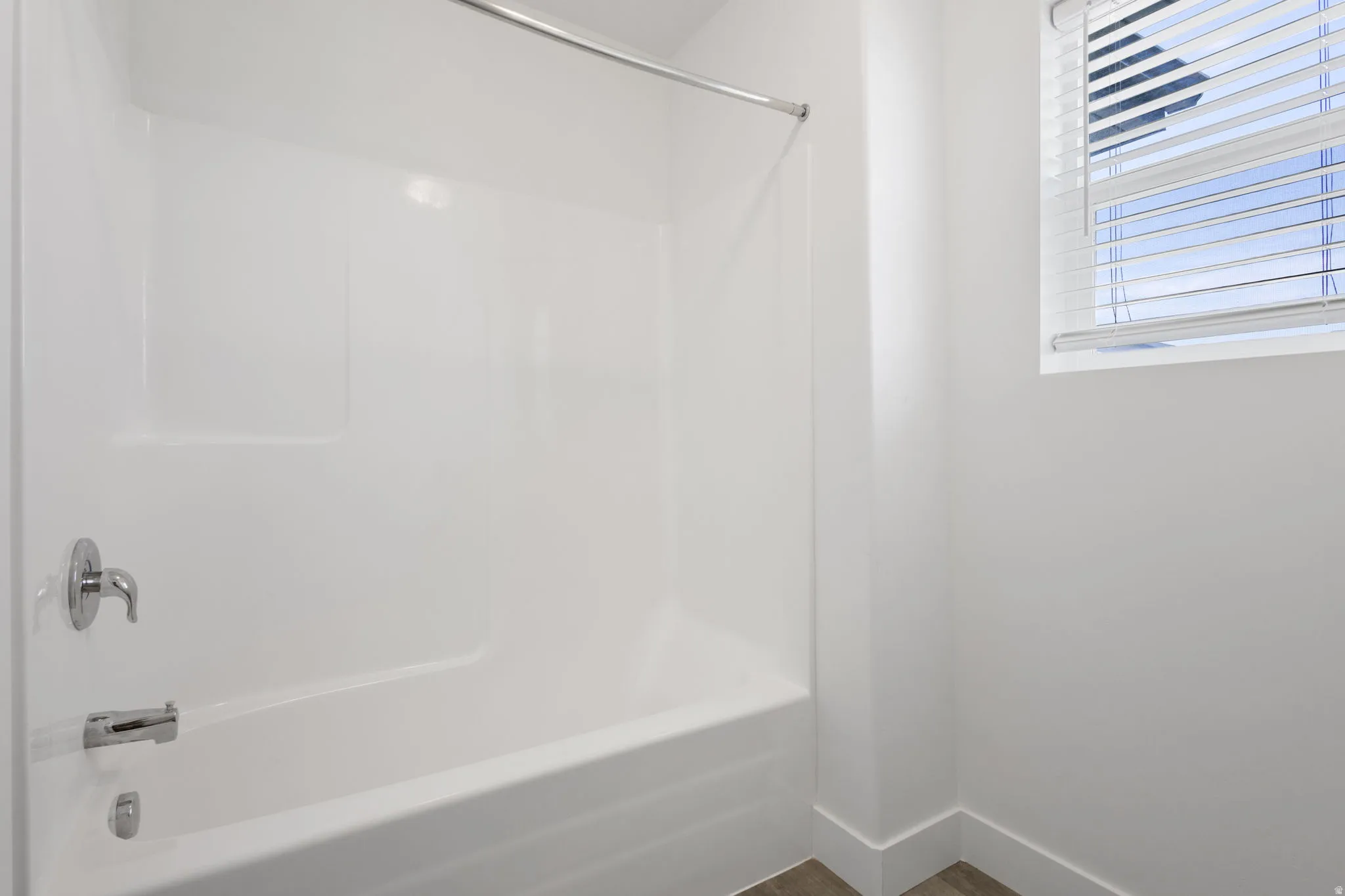 White tub-shower combination with chrome fixtures
