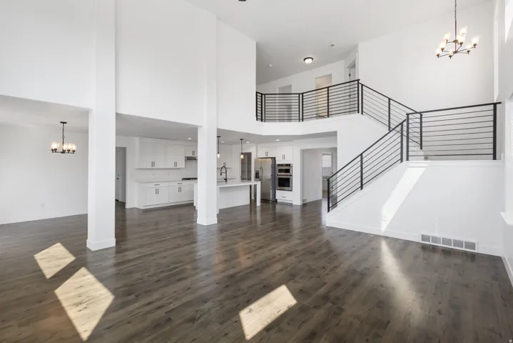 Open-concept living space anchored by soaring ceilings and abundant natural light