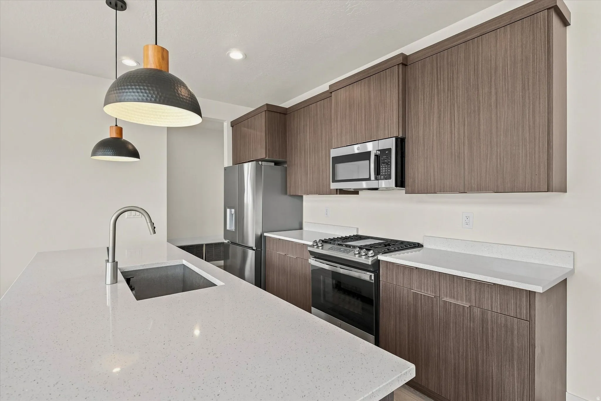 Modern kitchen featuring a stainless steel refrigerator, built-in microwave, and range with GAS cooktop