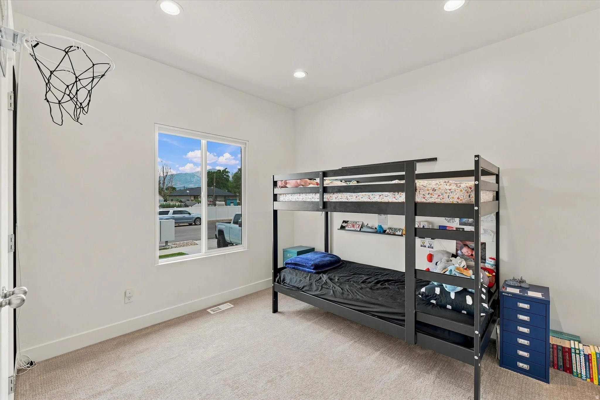 Recessed ceiling lighting, white walls, carpeted flooring, and a double-pane window