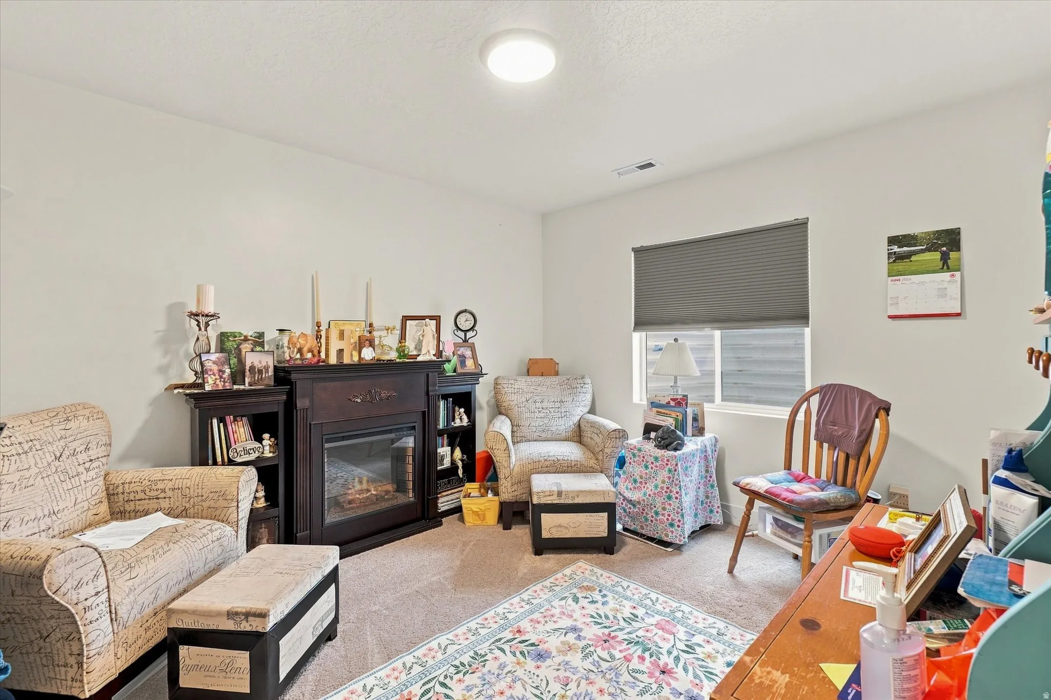 Built-in fireplace with dark wood mantel and surround, integrated shelving, and carpeted flooring