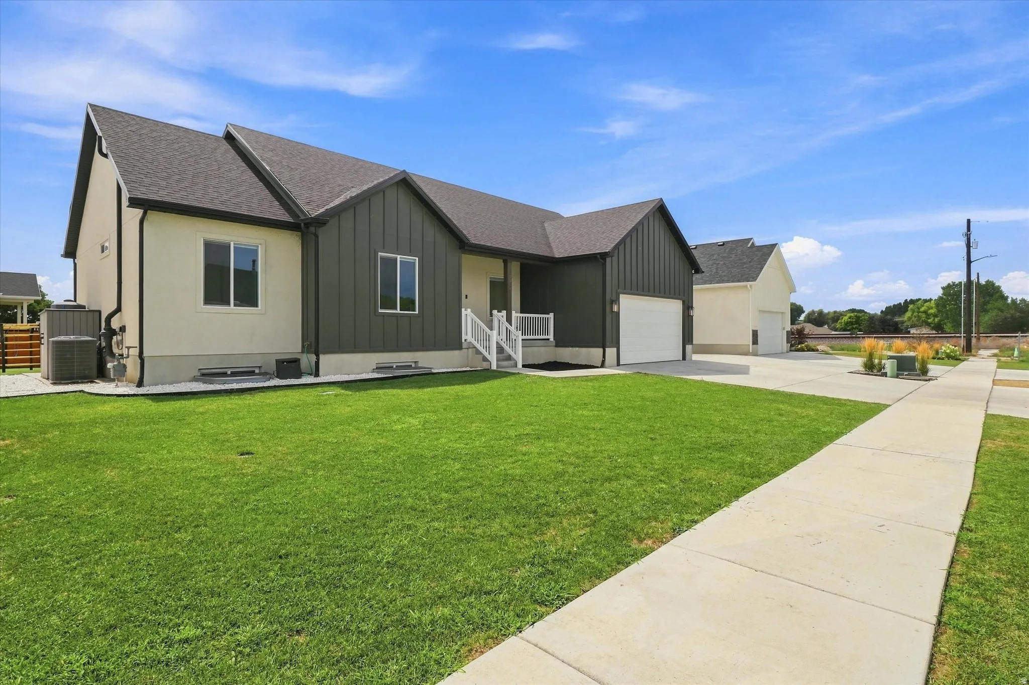 Modern exterior with dark vertical siding and light stucco finishes