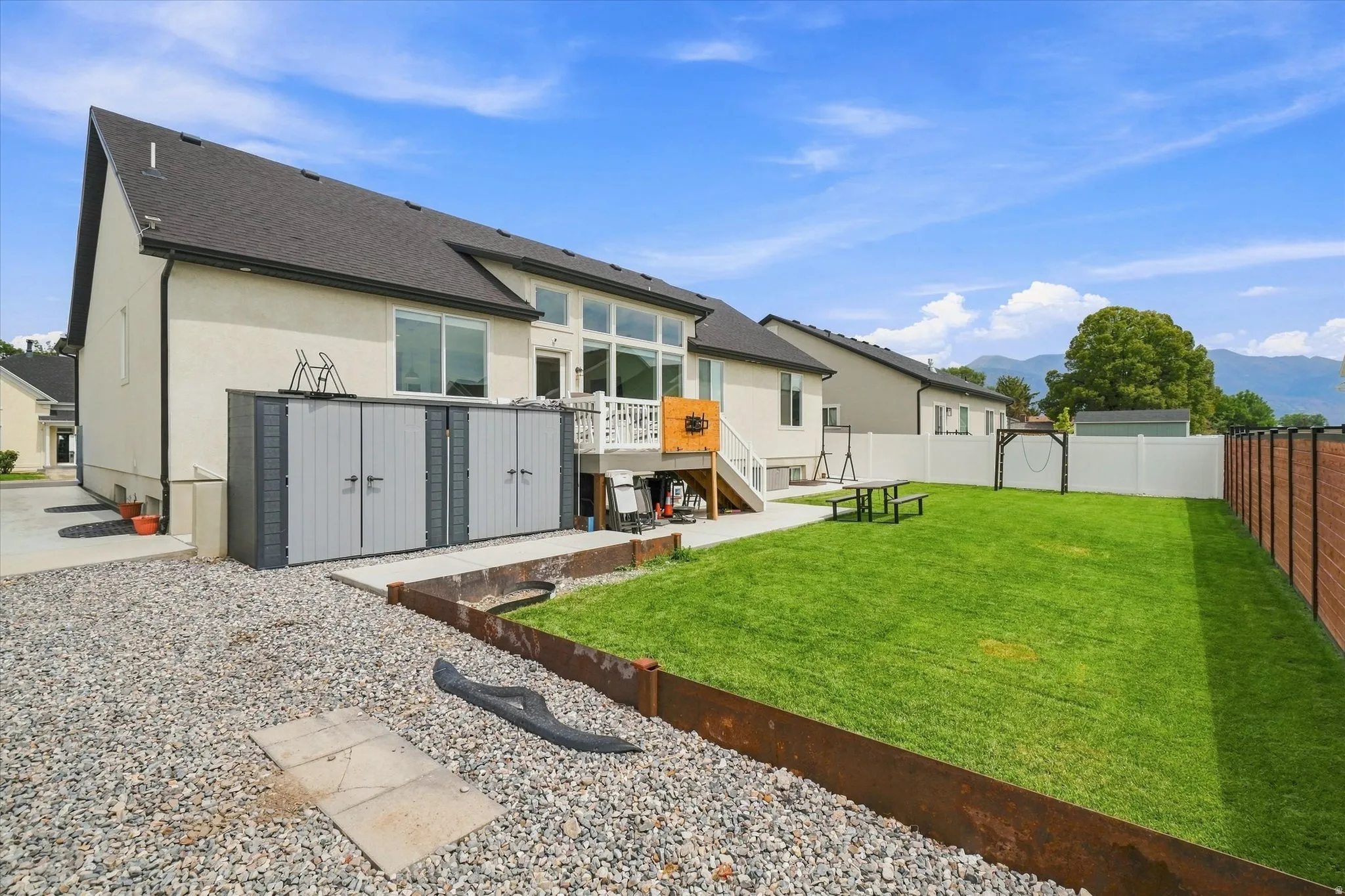 Manicured lawn with a white vinyl privacy fence and a wood-slat accent fence