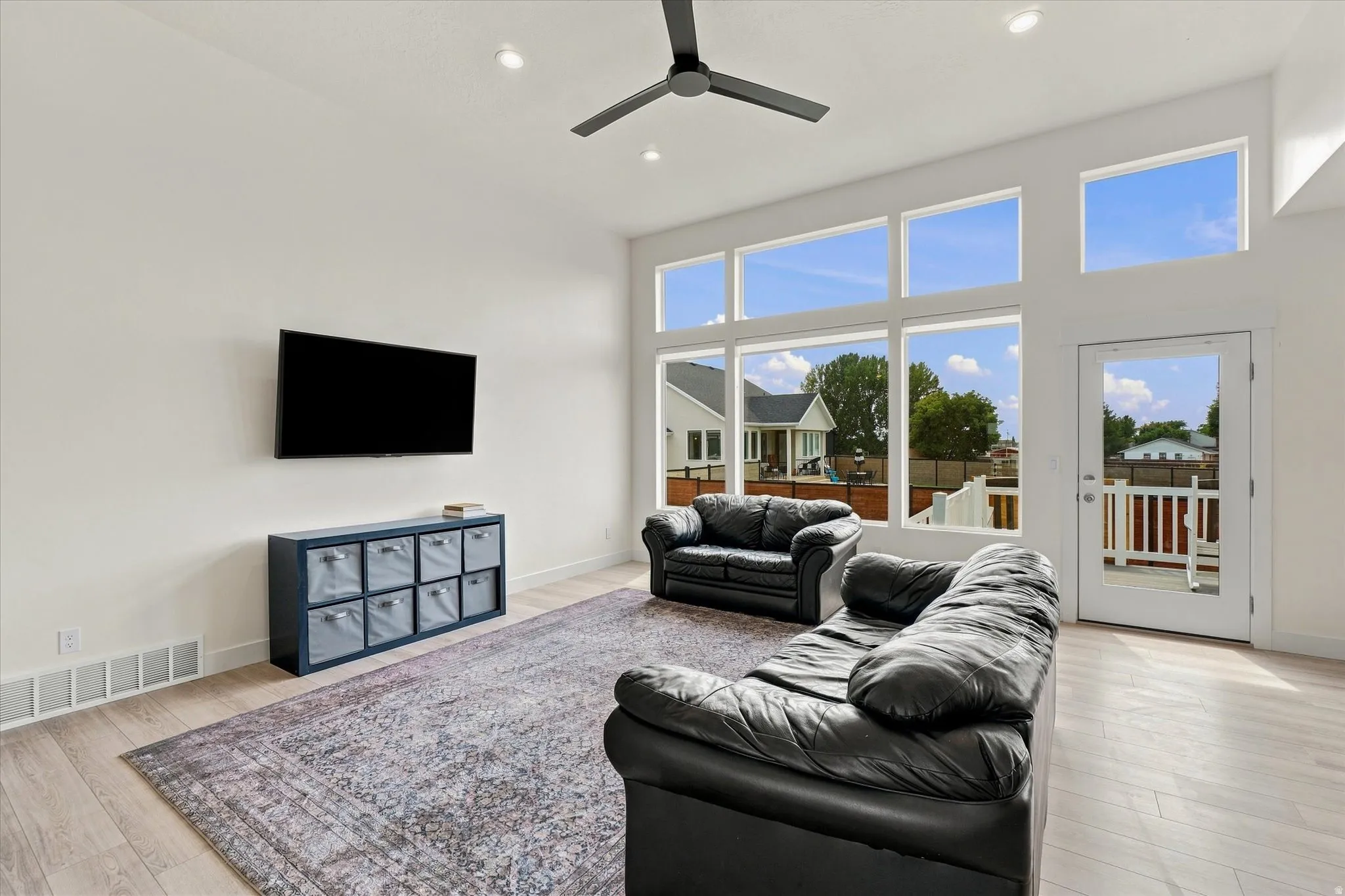 Expansive window wall with multiple panes and a glass-paneled door.  NATURAL LIGHT
