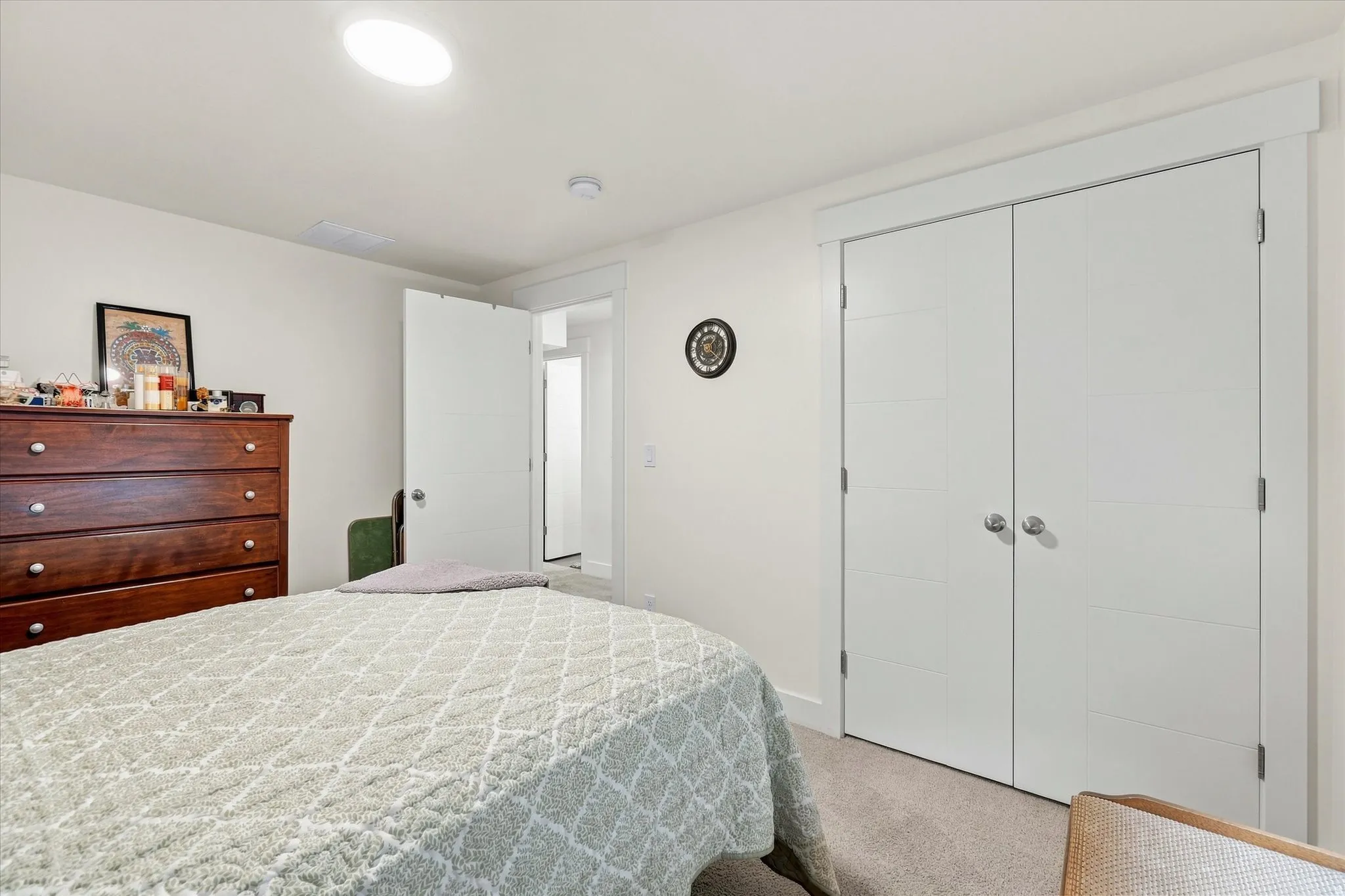 Recessed ceiling light, white paneled interior doors, and light-toned carpeting