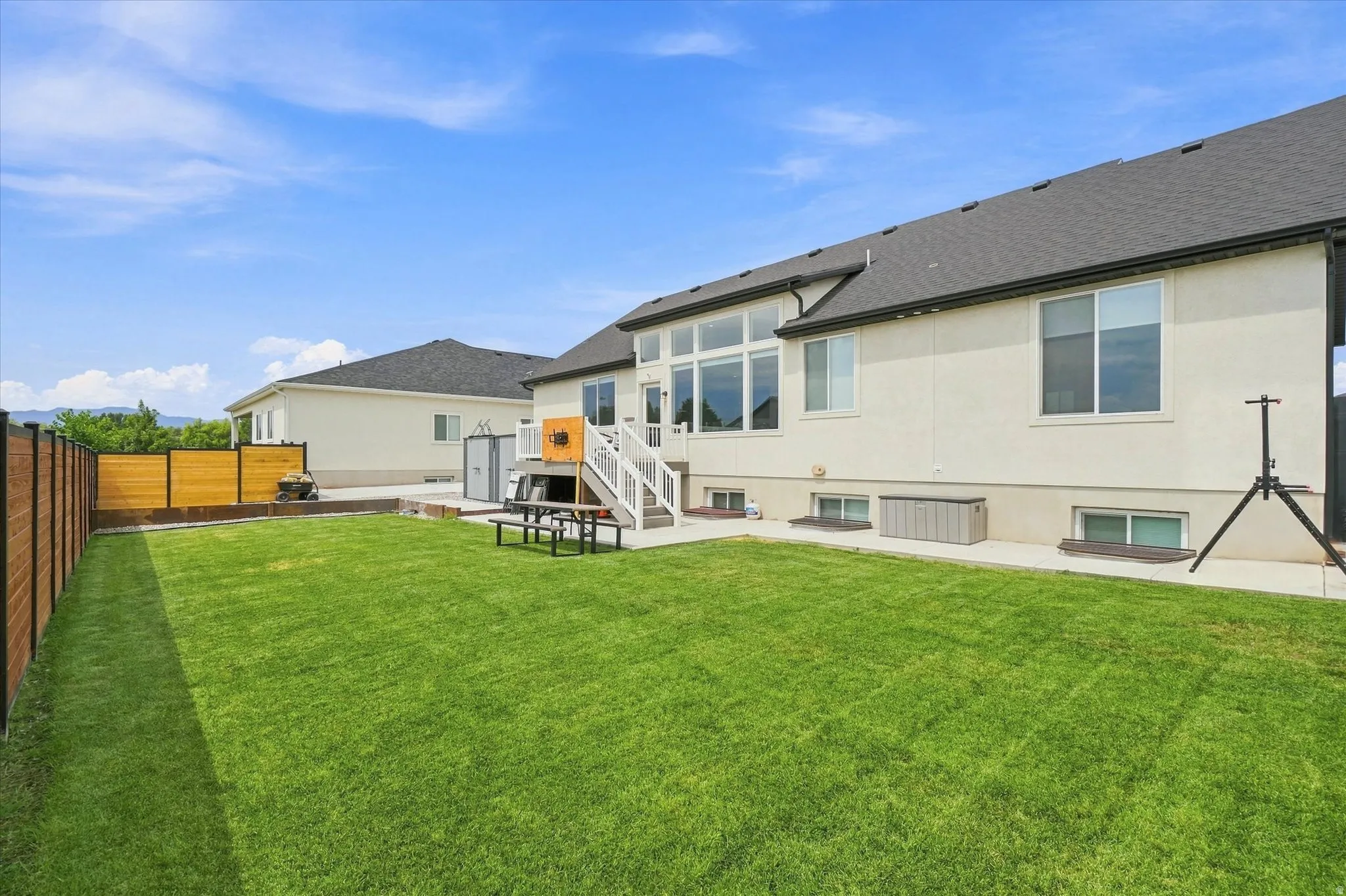 Expansive green lawn with a solid wood and metal fence