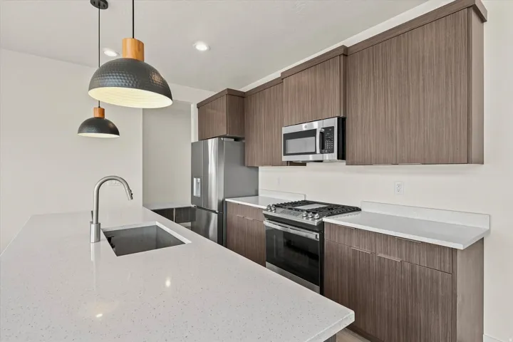 Modern kitchen featuring a stainless steel refrigerator, built-in microwave, and range with GAS cooktop