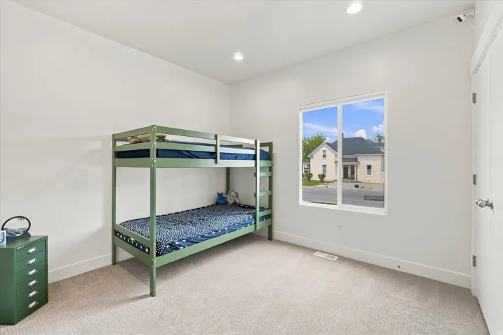 Recessed ceiling lighting, white walls, carpet flooring, and a white interior door with a silver knob