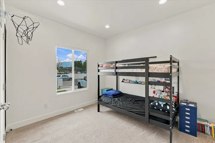 Recessed ceiling lighting, white walls, carpeted flooring, and a double-pane window