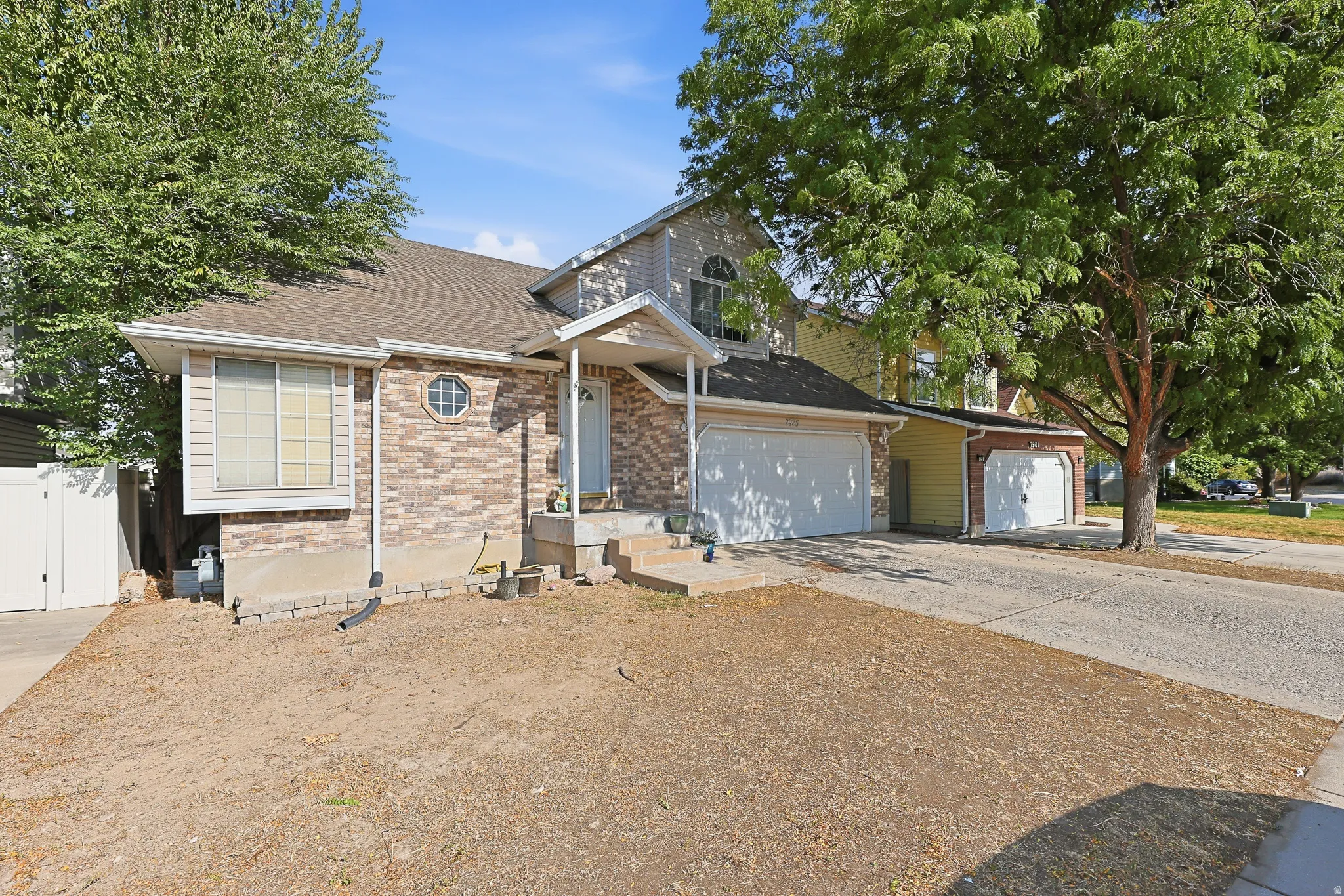 Brick facade with siding accents, arched transom window, and a two-car attached garage