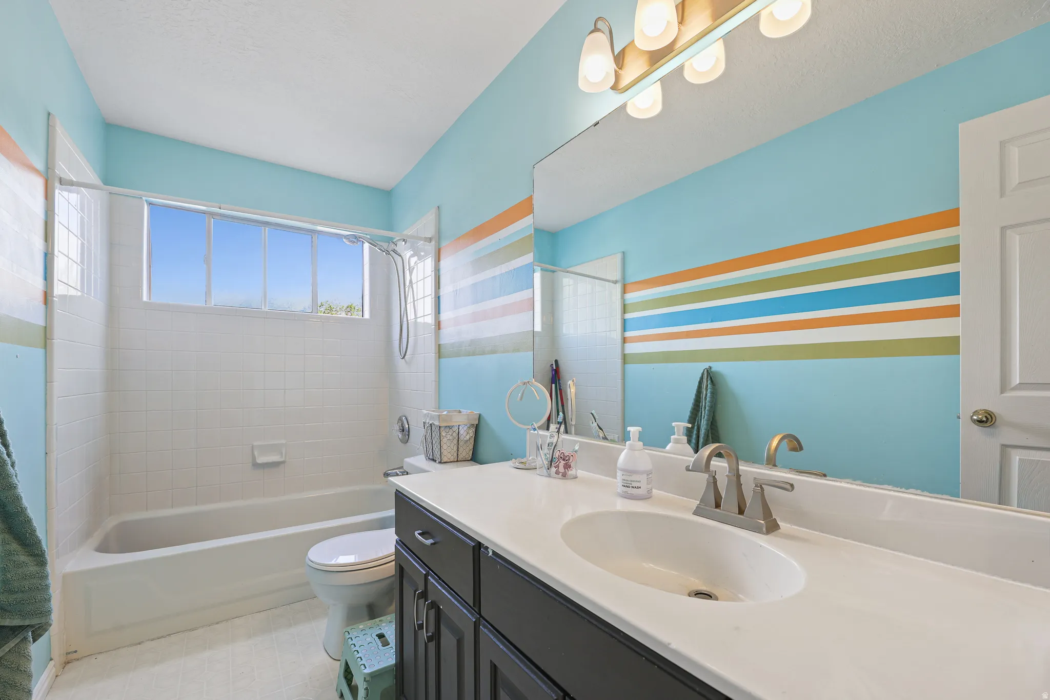 Spa-inspired bathroom featuring dual vanities with white quartz countertops, dark cabinetry, and brushed nickel fixtures