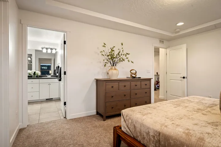White walls, tray ceiling, recessed lighting, and carpet flooring