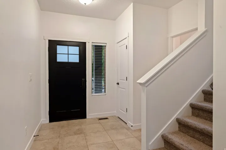 Entryway featuring a paneled door with windowpanes, a side window, and tile flooring