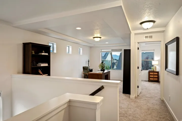Open common area featuring recessed lighting, a tray ceiling, and multiple windows