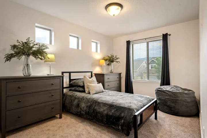 Multiple high-set windows, a large pane window with blinds, and a flush mount ceiling light fixture