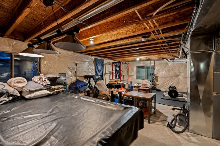 Exposed wood beam ceiling, track lighting, and a utility window