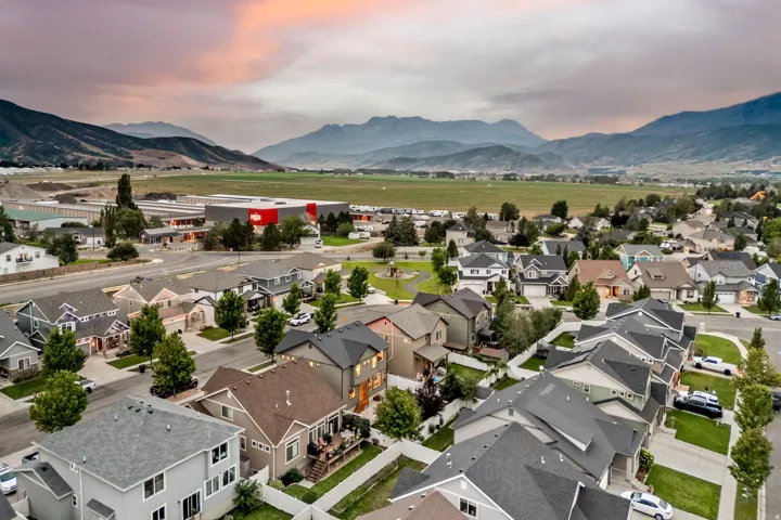 Residential community with diverse single-family homes, mature landscaping, and a central green space