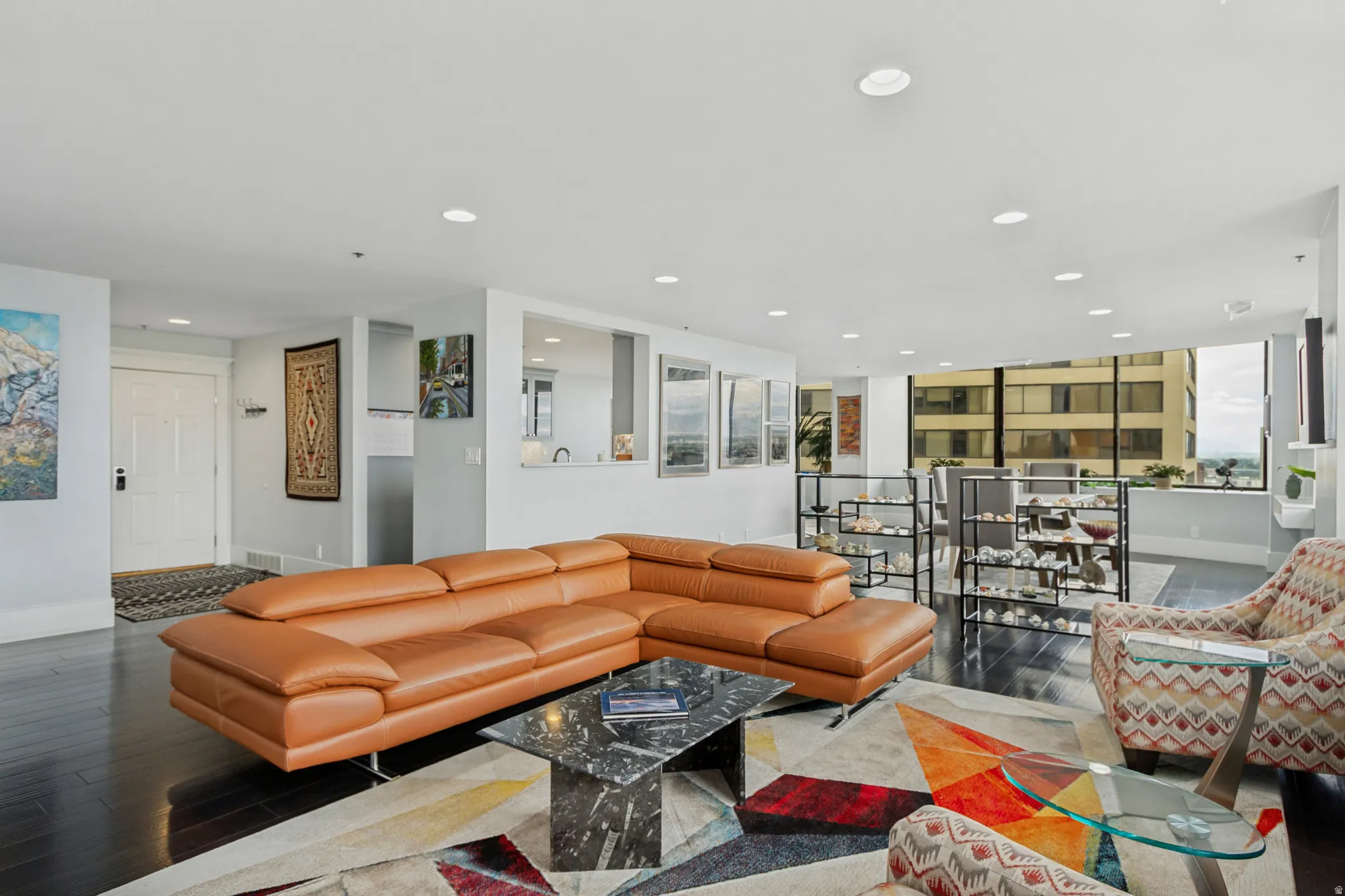 Open-concept living space featuring dark wood-finish flooring, recessed lighting, and expansive windows