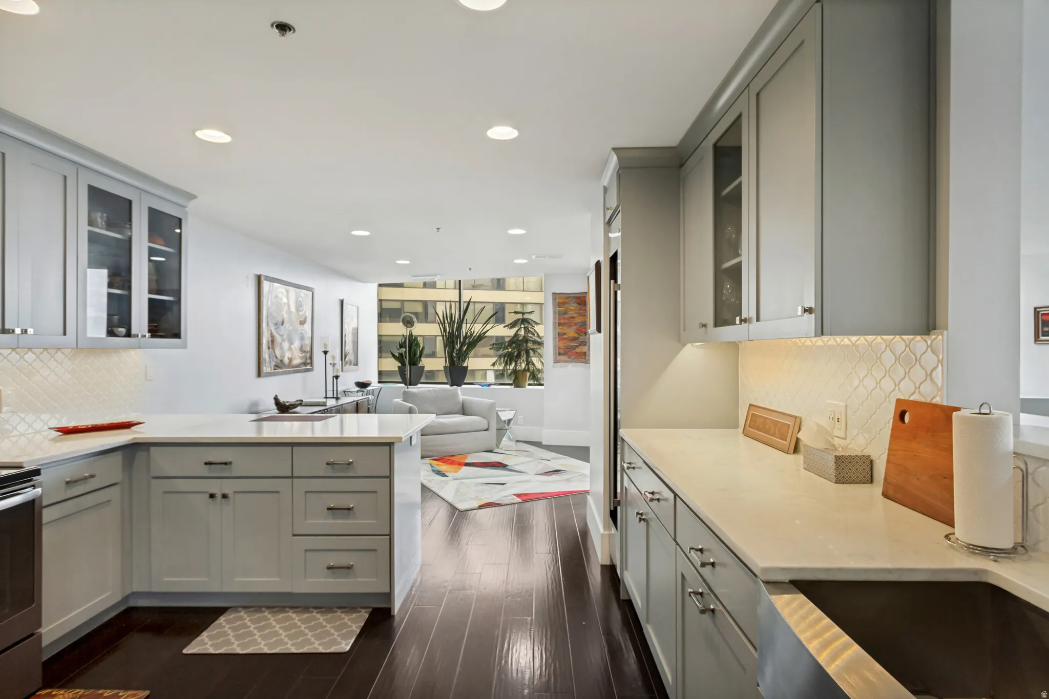 Kitchen featuring light-toned cabinetry, white countertops, and a decorative tile backsplash