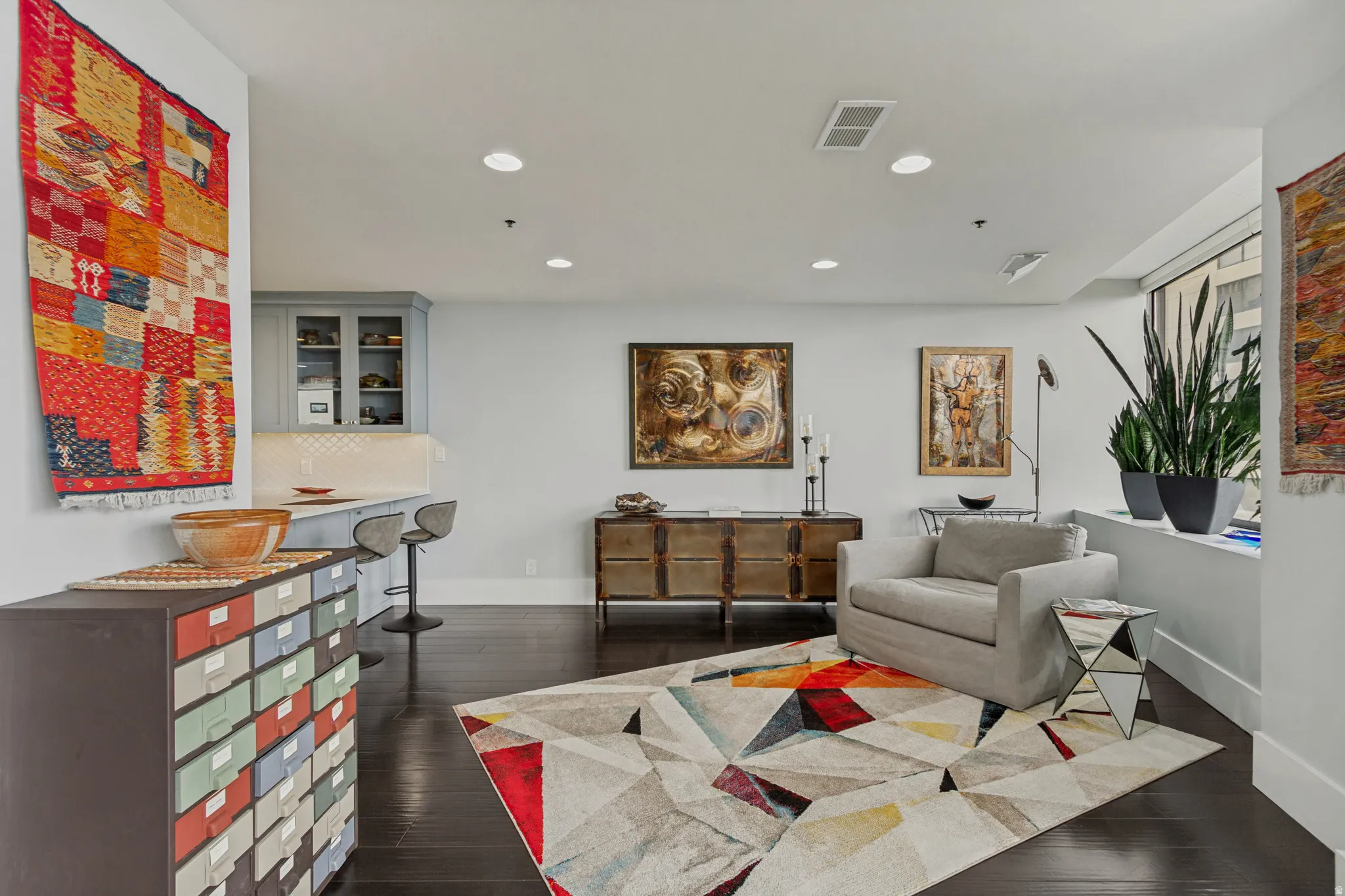 Contemporary studio featuring polished dark wood-finish flooring, recessed ceiling lighting, and white walls