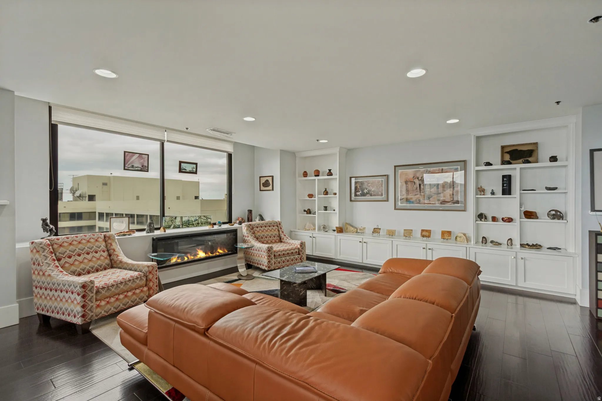 Hardwood flooring, recessed lighting, expansive windows, built-in shelving, and a linear fireplace