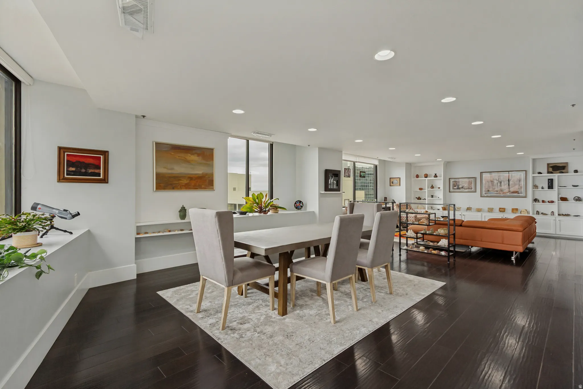 Expansive room with dark wood-finish flooring, recessed lighting, and large windows