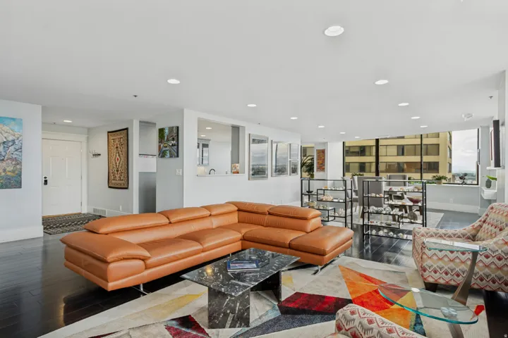 Open-concept living space featuring dark wood-finish flooring, recessed lighting, and expansive windows