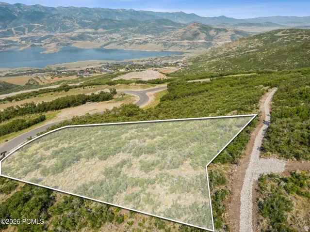Expansive parcel with mountainous terrain, natural vegetation, and paved road access