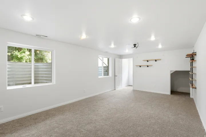 Bright room featuring recessed lighting, a door opening, two windows, and built-in shelving