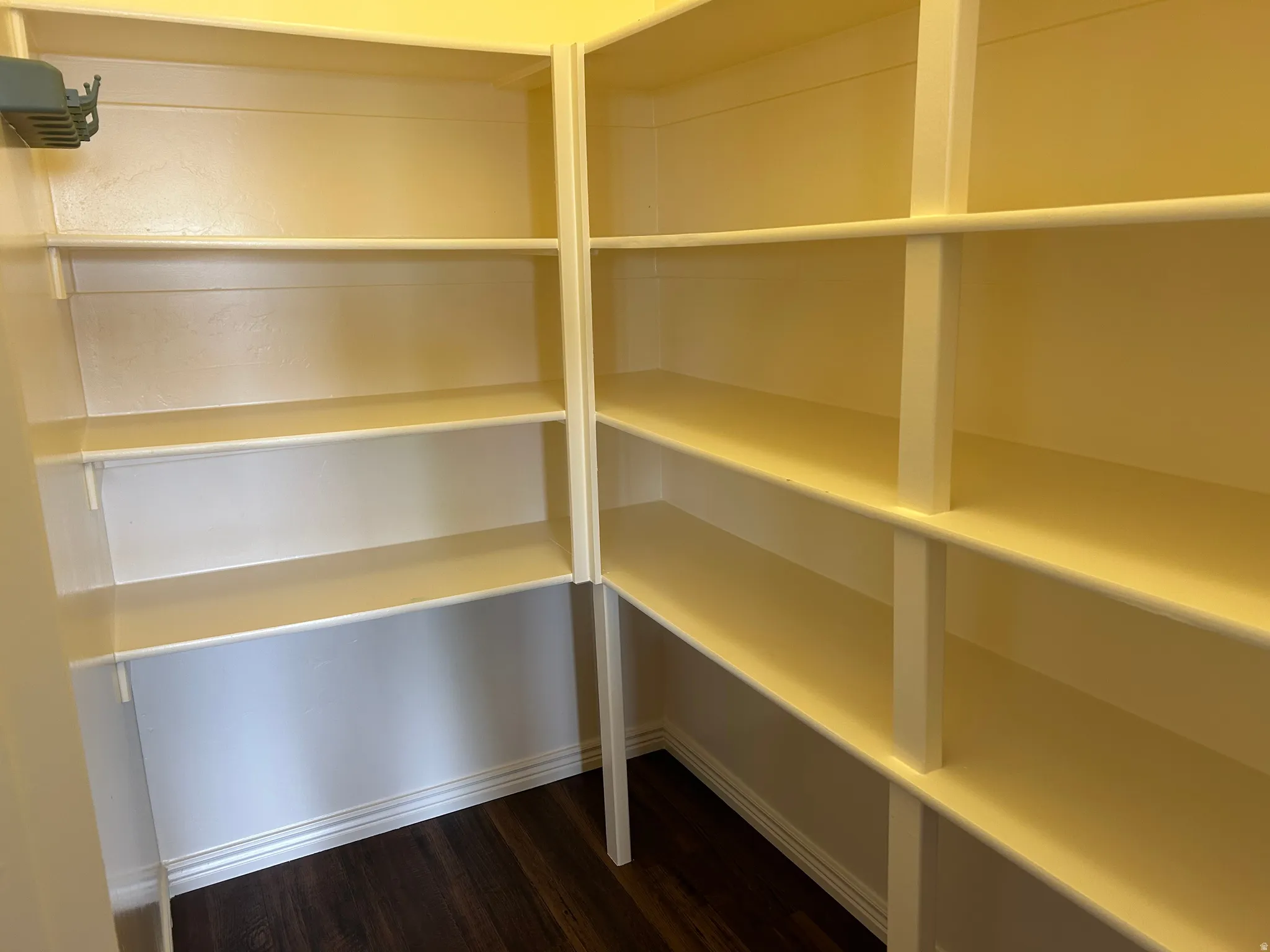 Built-in shelving with multiple levels, corner configuration, and wood-finish flooring