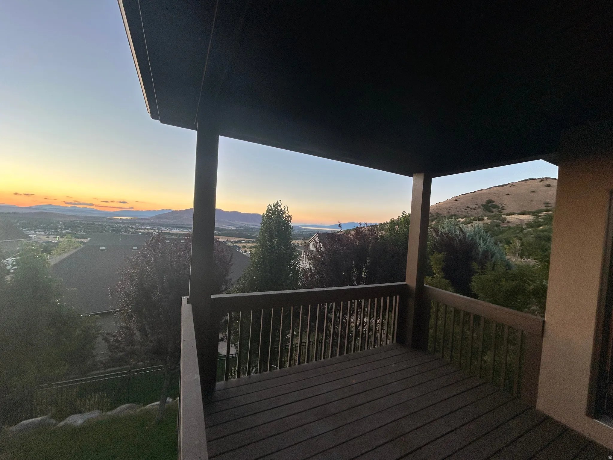 Covered outdoor deck with wood-finish decking and railing