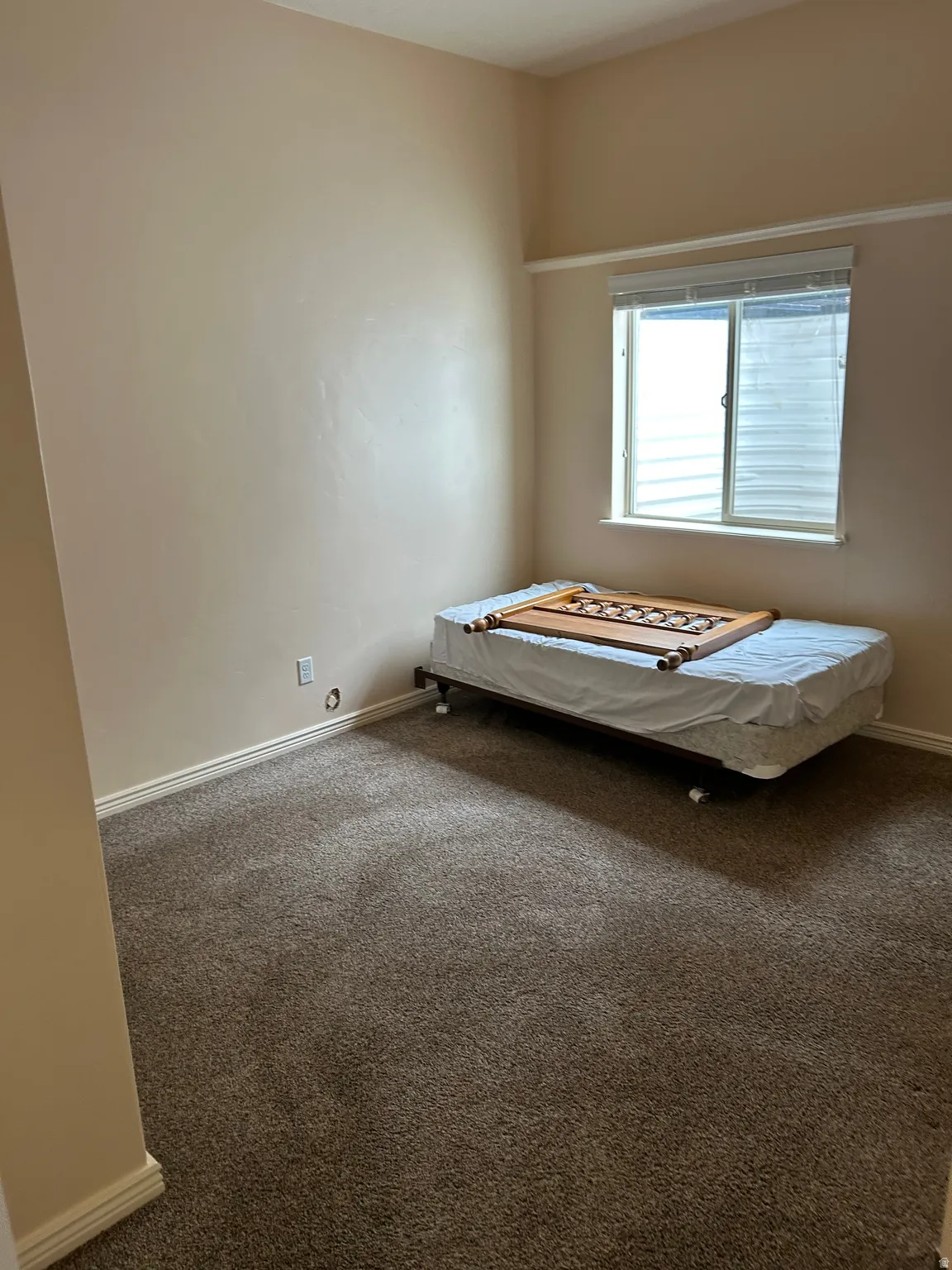 Neutral-toned walls complement the brown carpet flooring