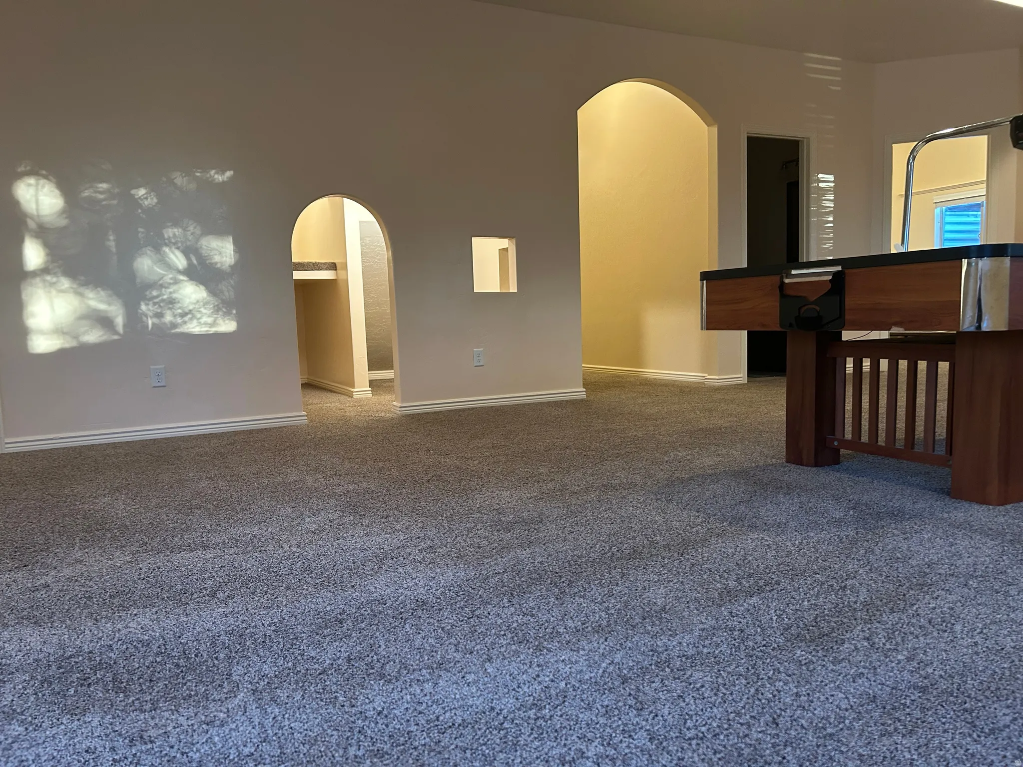 Archway openings, light gray carpeting, and white trim