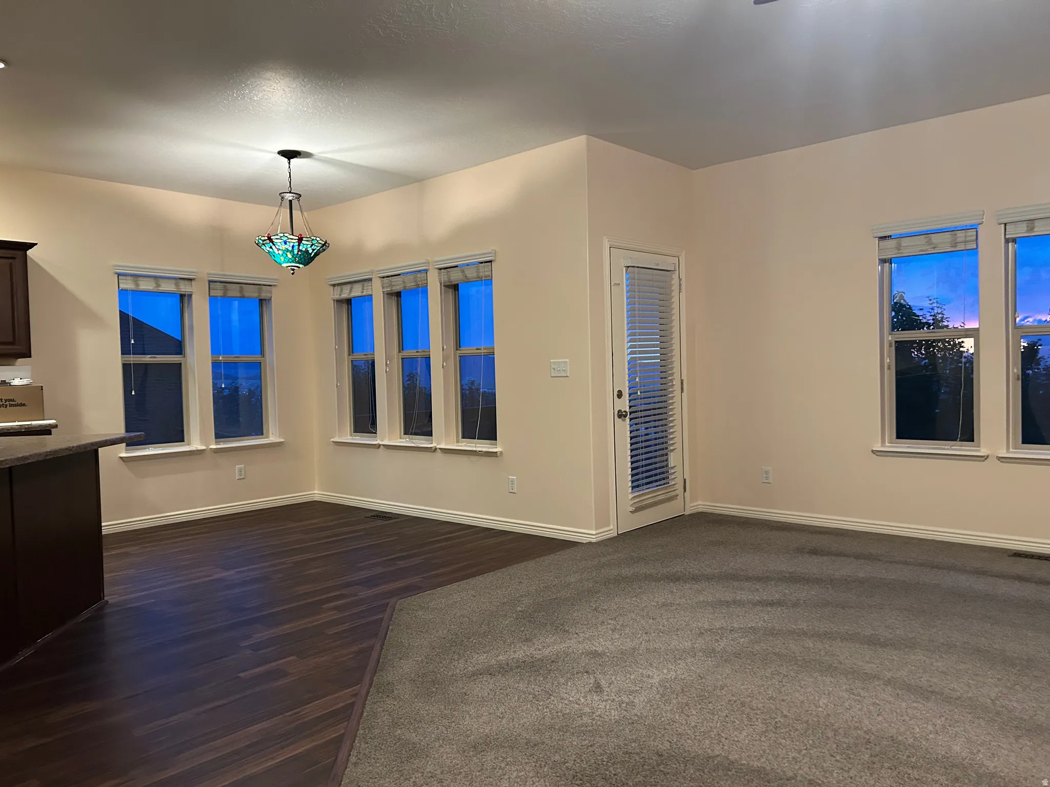 Open-concept living space featuring wood-finish flooring, recessed lighting, and a decorative chandelier