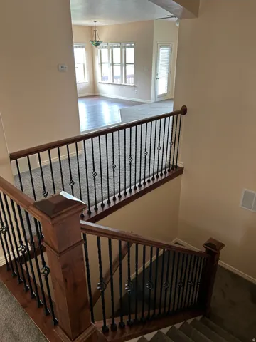 Staircase with wood-finish handrails and decorative wrought iron balusters