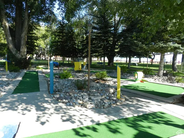 Miniature golf course featuring multiple holes with artificial turf, paved walkways, and decorative rock landscaping