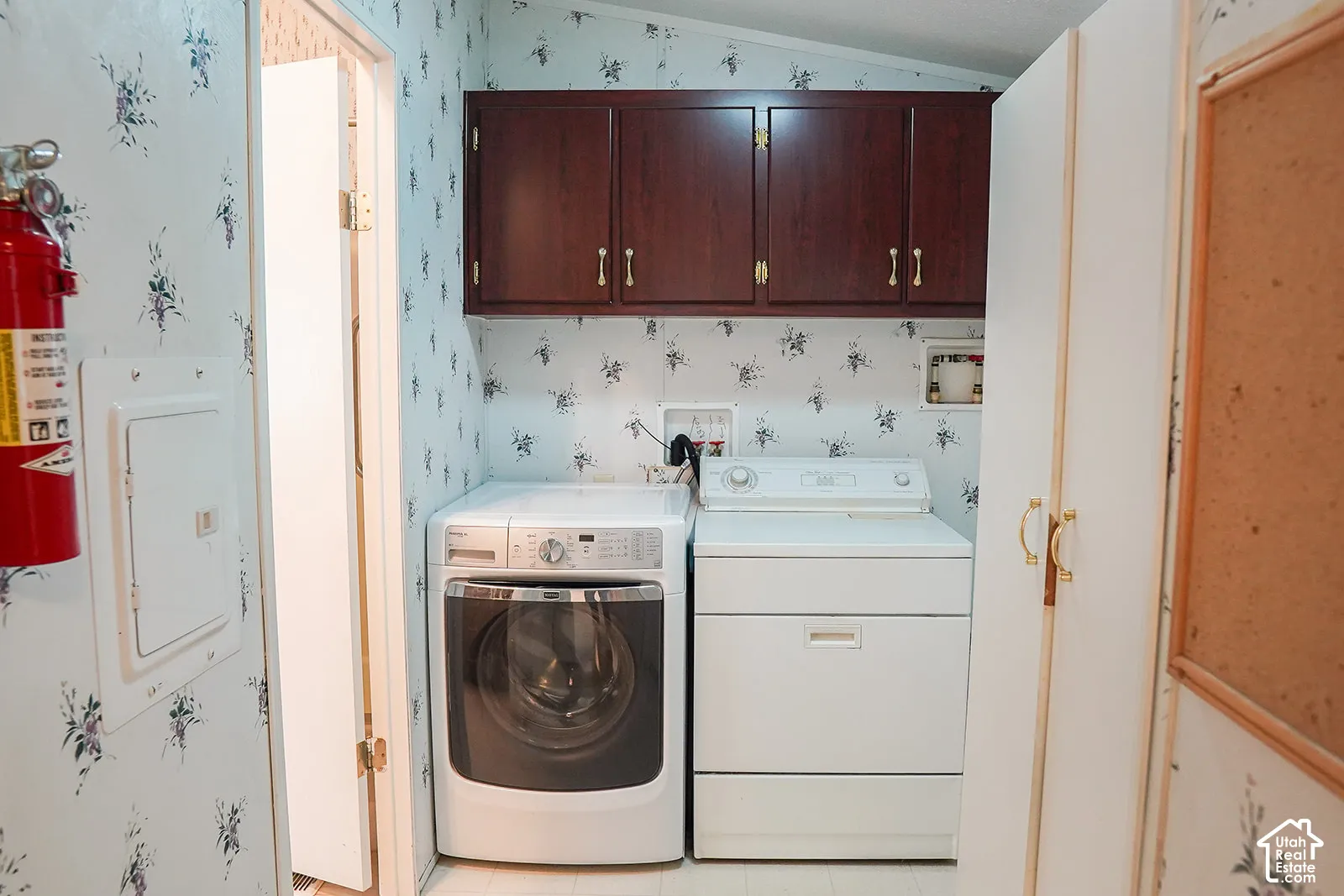 Laundry area featuring upper cabinetry, a front-load washer, and a top-load dryer